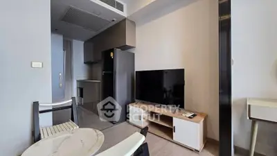 Modern living room with sleek kitchen and stylish furniture in a contemporary apartment.