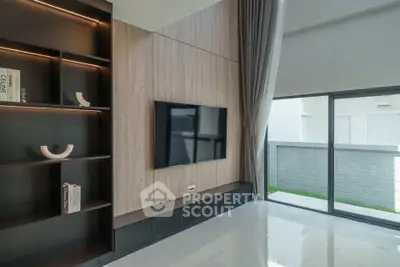 Modern living room with sleek design, large window, and built-in shelving.