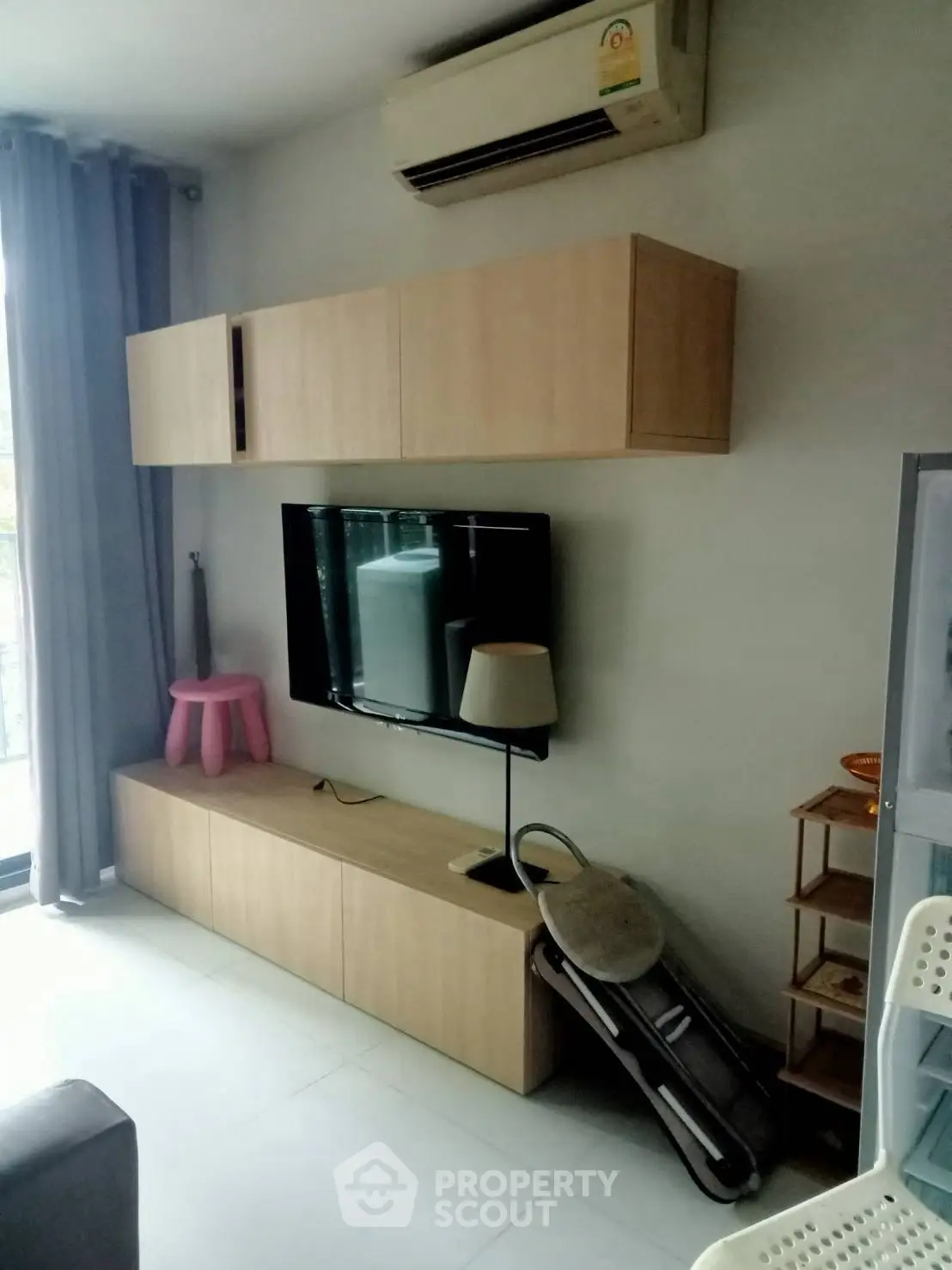 Modern living room with wall-mounted TV and sleek wooden cabinets