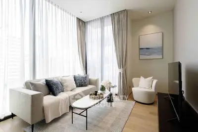 Elegant living room with modern decor and floor-to-ceiling windows