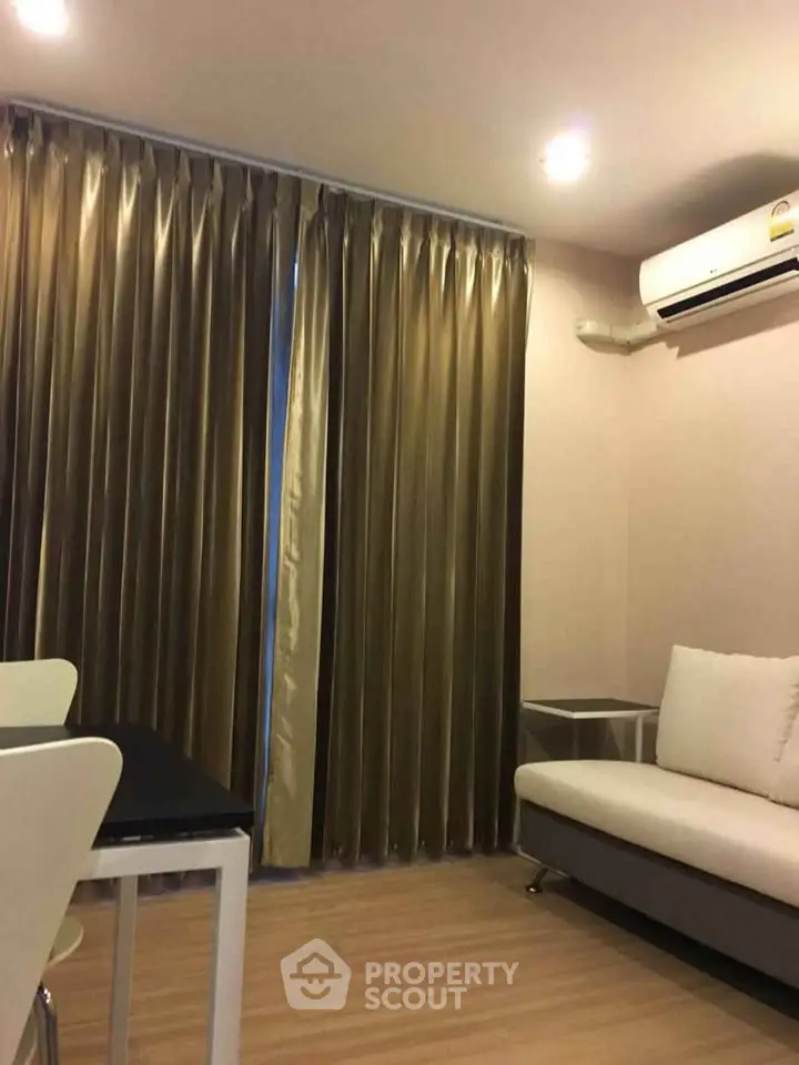 Cozy living room with modern sofa and elegant curtains, featuring a sleek air conditioning unit.