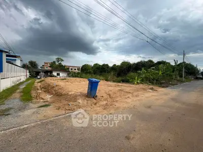 Vacant land plot with potential for development under cloudy skies.