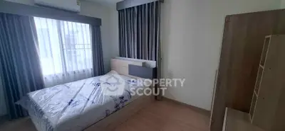 Cozy bedroom with natural light and modern furnishings in a stylish apartment.
