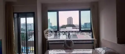 Spacious bedroom with large windows offering stunning city views and natural light.