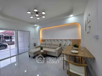 Modern living room with elegant lighting and marble accents, featuring a cozy sofa and dining area.