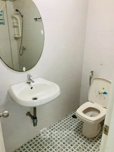 Compact bathroom with round mirror and tiled flooring