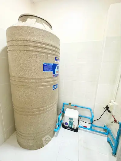 Spacious utility room with water tank and pump system, ideal for efficient water management.