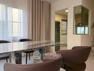 Elegant dining area with marble table and modern chairs in a stylish home interior.