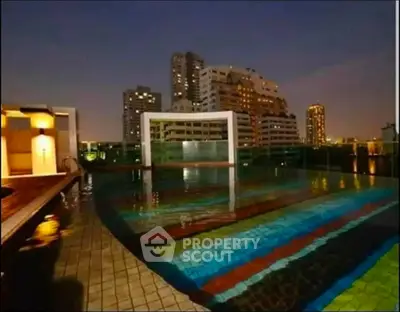 Stunning rooftop pool with city skyline views at night, perfect for luxury urban living.