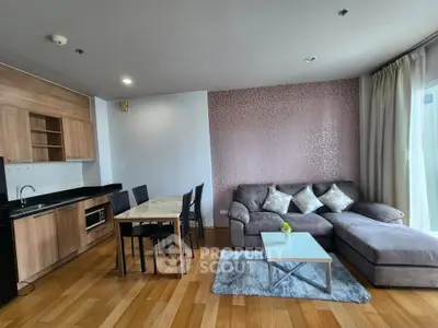 Modern living room with open kitchen, featuring a cozy sectional sofa and dining area, perfect for urban living.