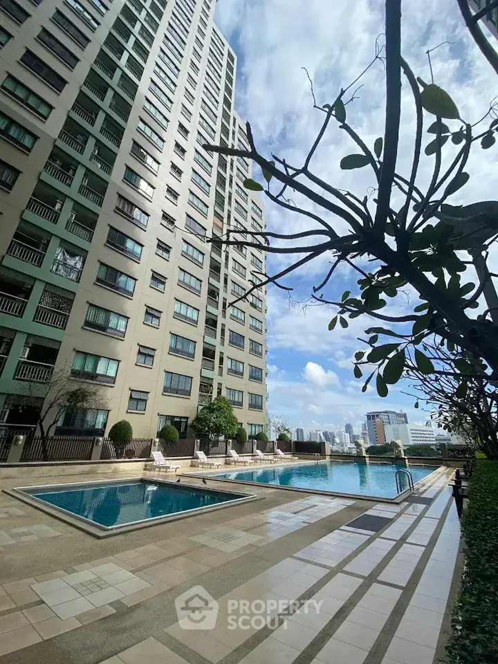 Luxurious high-rise building with stunning pool and city views, perfect for urban living.