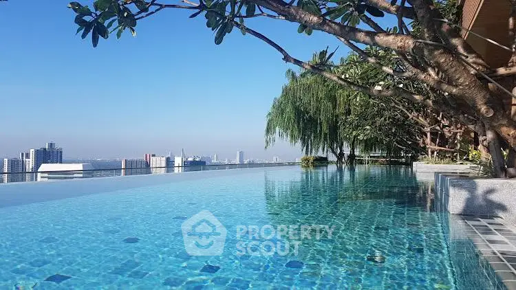 Luxurious rooftop infinity pool with stunning city skyline view, perfect for relaxation and leisure.