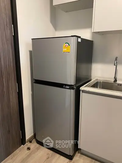 Modern kitchen with sleek refrigerator and stainless steel sink