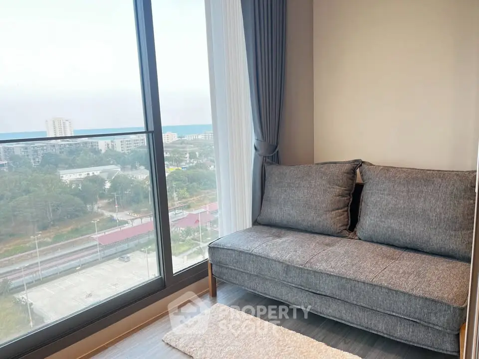 Cozy living room with a stunning city view from a high-rise apartment window.