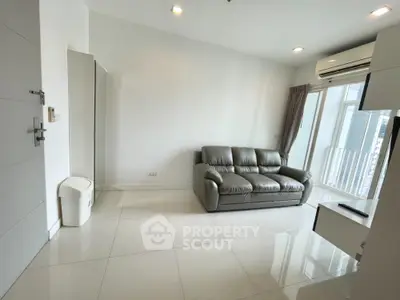 Modern living room with sleek sofa and air conditioning, featuring bright natural light and minimalist design.