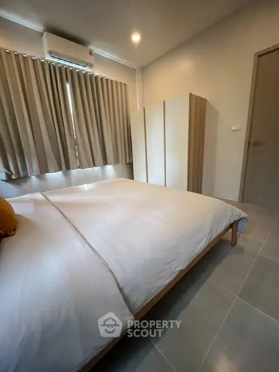 Cozy bedroom with modern furnishings and natural light, perfect for relaxation and comfort.