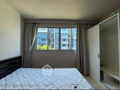 Bright bedroom with large window and modern wardrobe in urban apartment