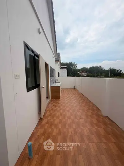 Spacious balcony with wooden flooring and scenic view, perfect for outdoor relaxation.