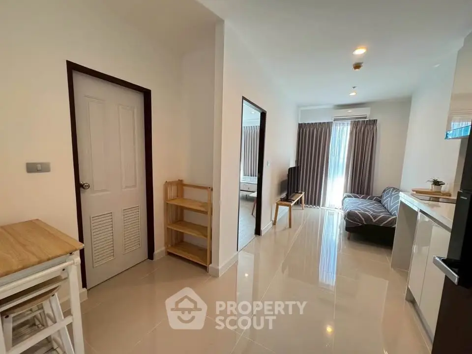 Modern apartment interior with open layout, featuring a cozy living area and natural light.