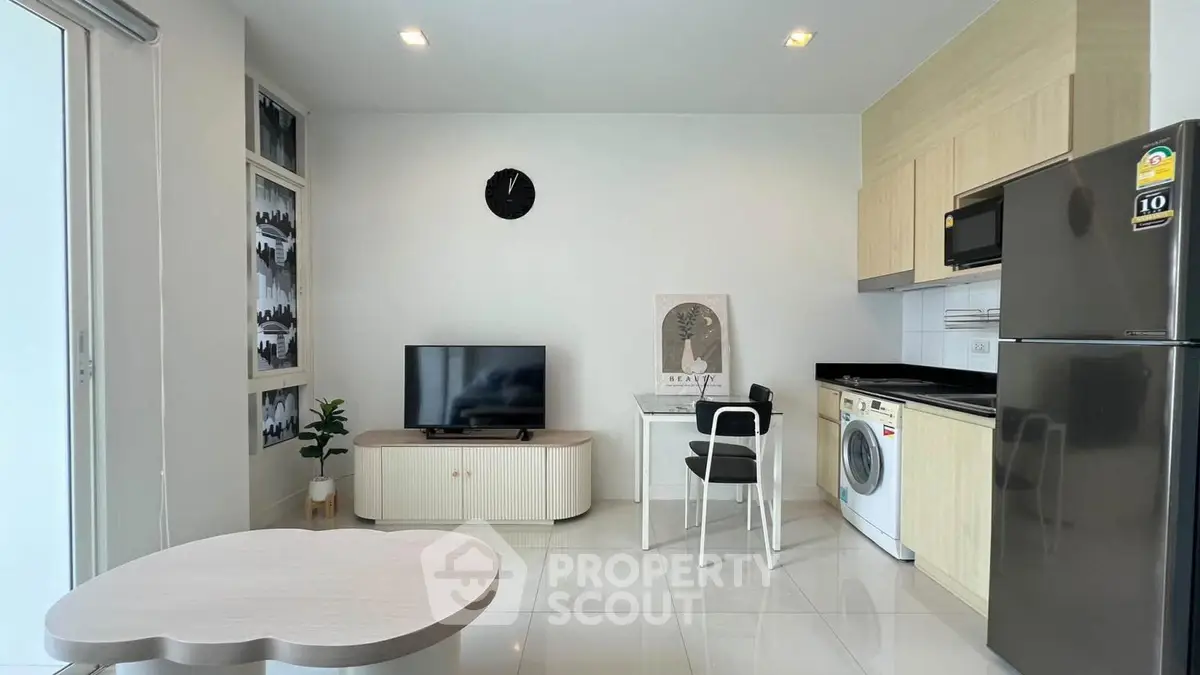 Modern living room with sleek kitchen and appliances in open layout