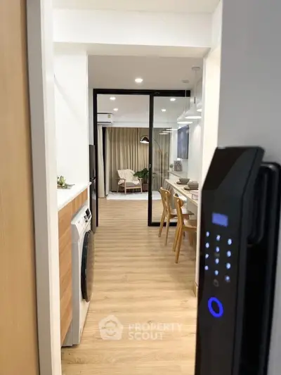 Modern apartment entrance with digital lock, open kitchen, and stylish living area.