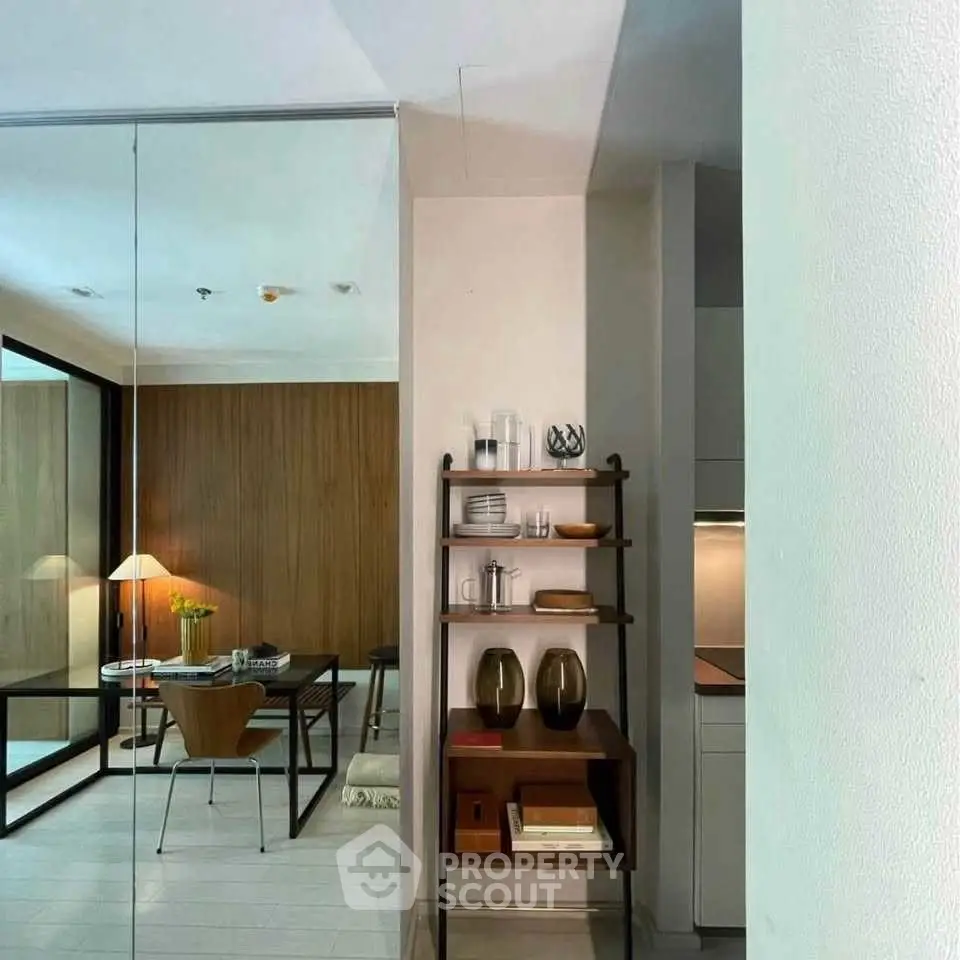 Stylish modern living room with elegant decor and dining area, featuring sleek furniture and warm lighting.