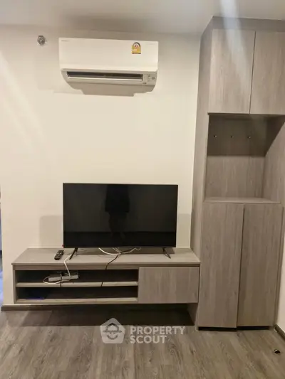 Modern living room with sleek TV stand and air conditioning unit, perfect for cozy entertainment.