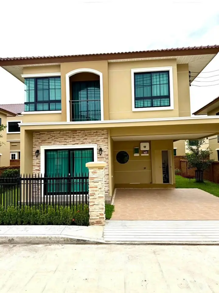 Modern two-story house with large windows and a spacious driveway in a suburban neighborhood.