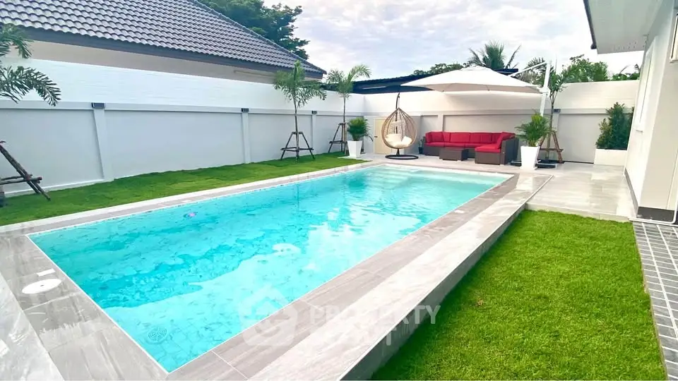 Luxurious backyard with modern pool and stylish seating area, perfect for relaxation and entertainment.