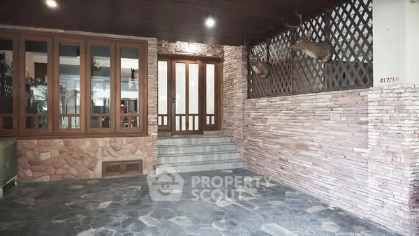 Charming entrance with stone facade and decorative deer mounts