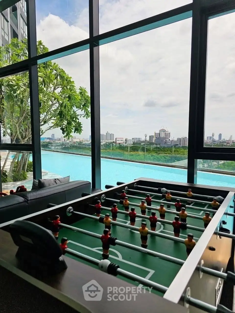 Luxurious building with stunning poolside view and foosball table, perfect for relaxation and entertainment.