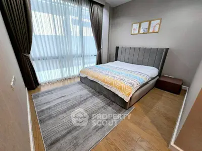 Modern bedroom with stylish decor, large window, and cozy bed in a contemporary apartment.