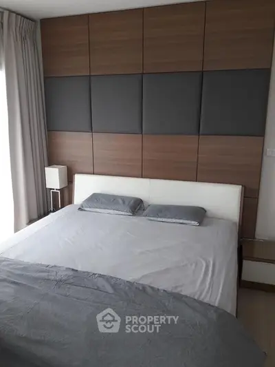 Modern bedroom with stylish wood paneling and cozy bedding