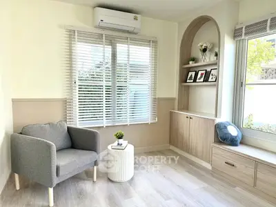Modern living room with stylish decor, large window, and cozy seating area.