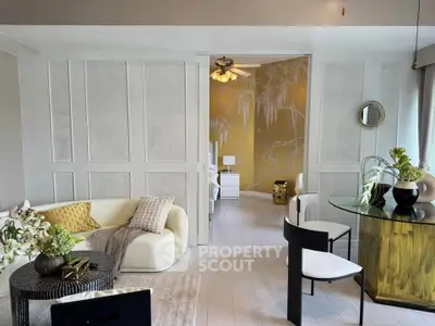 Stylish living room with modern decor and open layout, featuring elegant furniture and artistic wall design.
