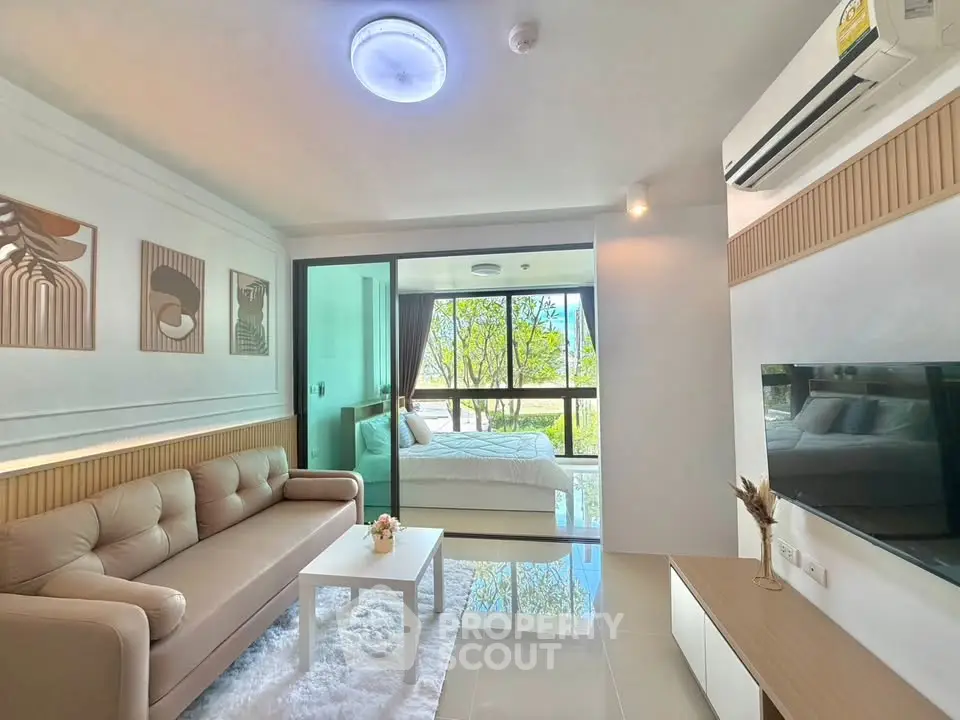 Modern living room with cozy sofa and large window view, connected to a stylish bedroom.