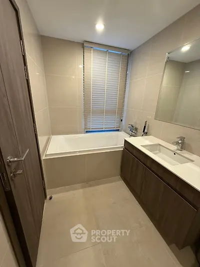 Modern bathroom with sleek design, featuring a bathtub and stylish vanity in a contemporary apartment.
