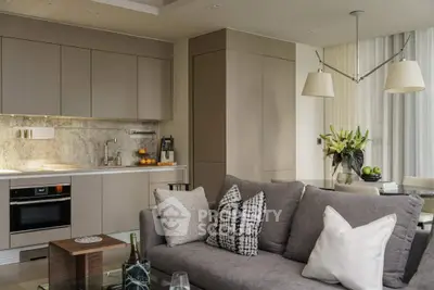 Modern open-layout kitchen and living room with stylish decor and neutral tones.