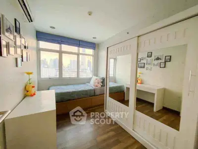 Charming bedroom with city view, featuring large windows and stylish decor, perfect for urban living.