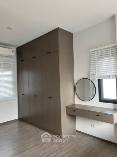 Modern bedroom with sleek built-in wardrobe and vanity mirror
