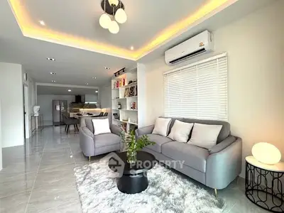 Modern living room with stylish decor and open layout, featuring cozy seating and ambient lighting.