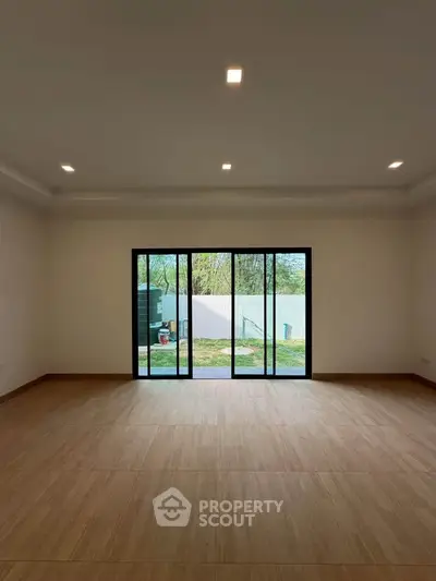 Spacious living room with large sliding glass doors opening to a serene garden view.