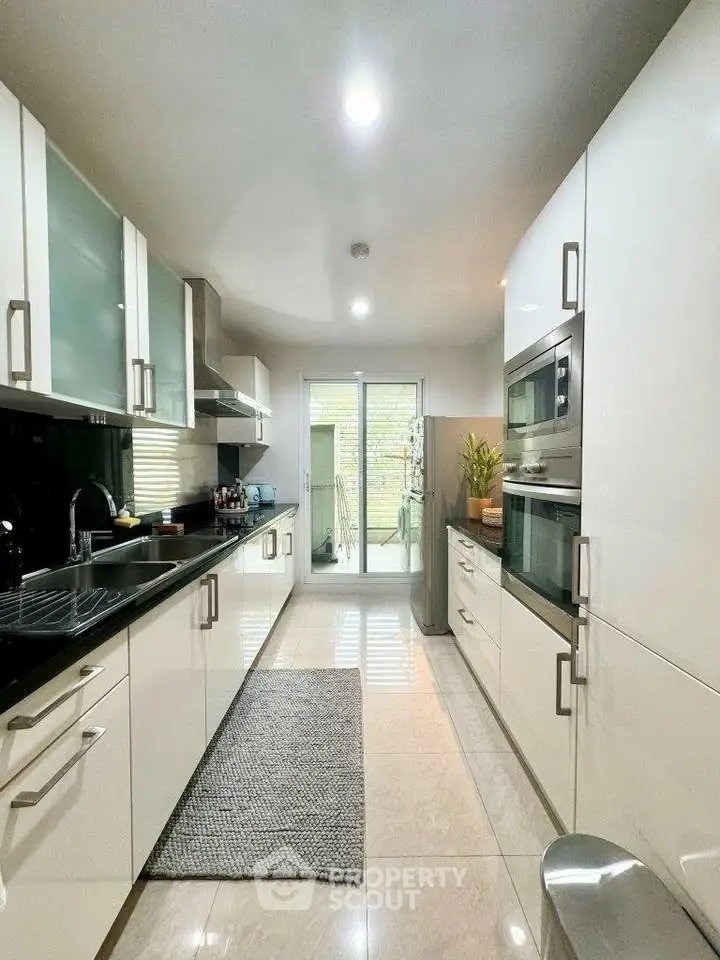 Modern kitchen with sleek white cabinets and stainless steel appliances