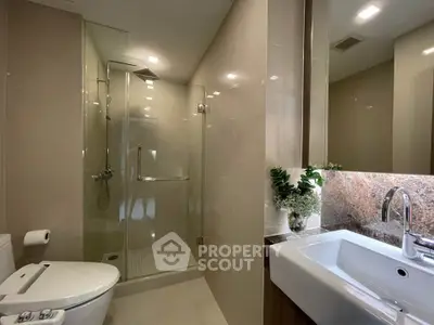 Modern bathroom with glass shower and sleek fixtures in a contemporary apartment.