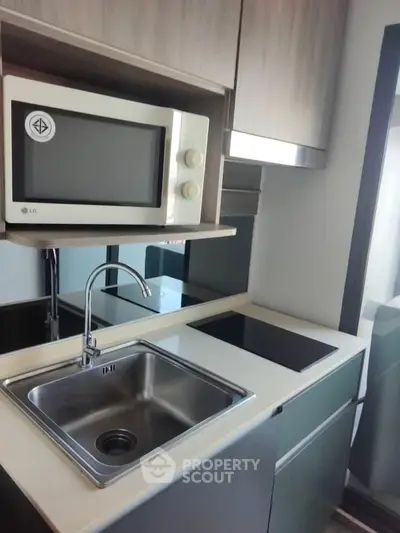 Modern compact kitchen with sleek design and built-in microwave