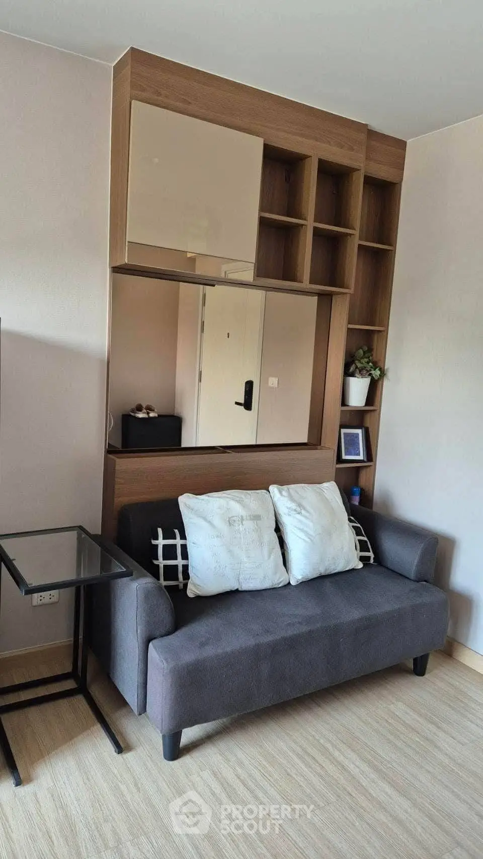 Cozy living room with modern sofa and stylish shelving unit, perfect for urban living.