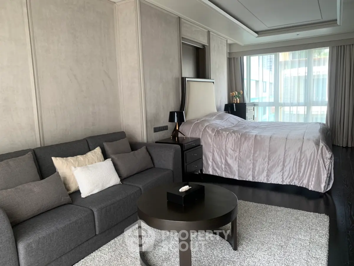 Luxurious bedroom with elegant decor and spacious seating area in modern apartment.