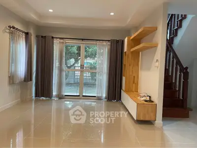 Spacious living room with large windows and modern wooden accents