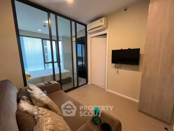 Modern living room with glass partition and cozy furnishings in a stylish apartment.