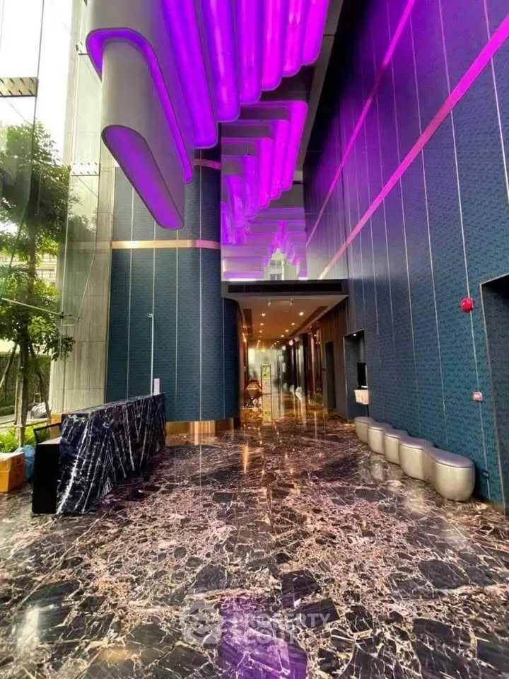 Luxurious modern building entrance with marble floors and vibrant purple lighting